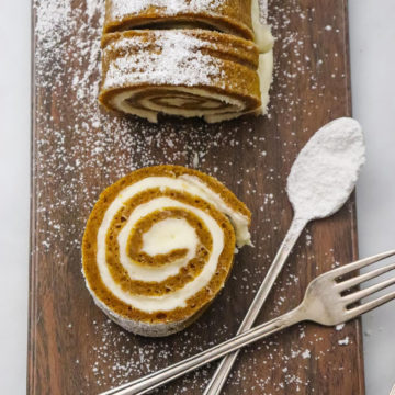 pumpkin roll on a wooden board with a fork and spoon