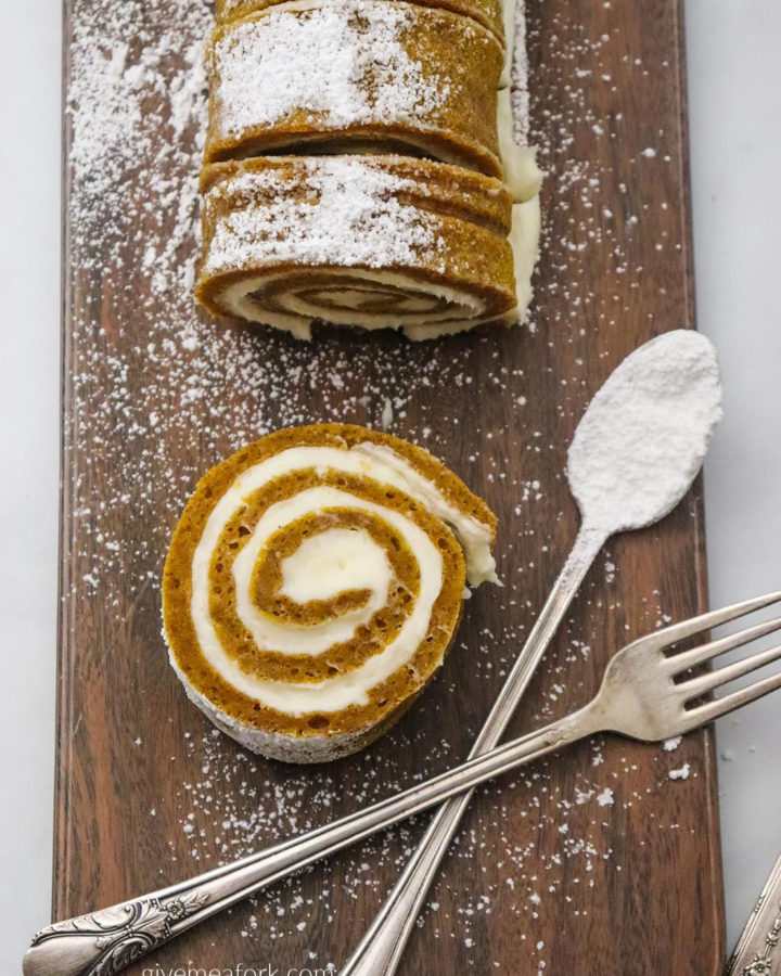 pumpkin roll on a wooden board with a fork and spoon