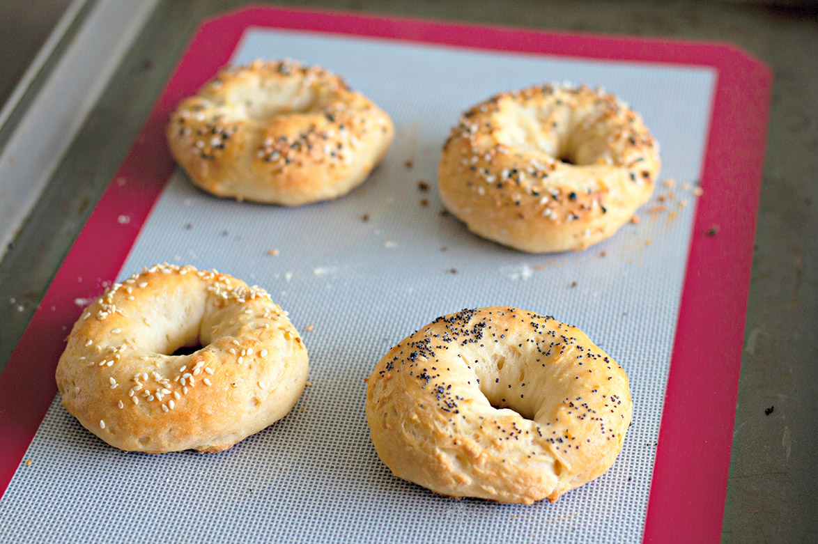 4 baked Greek yogurt bagels on a silicone mat 