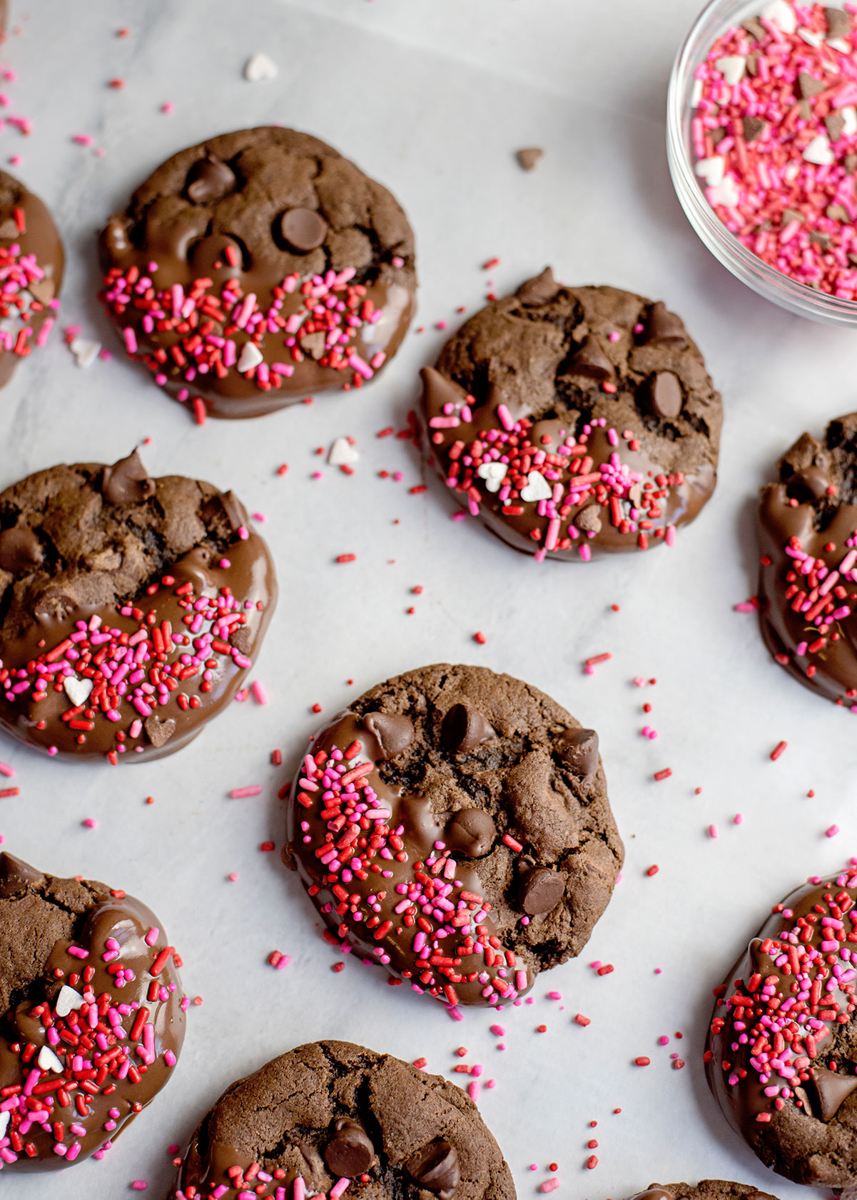 chocolate cookies with pink sprinkles on parchment paper 