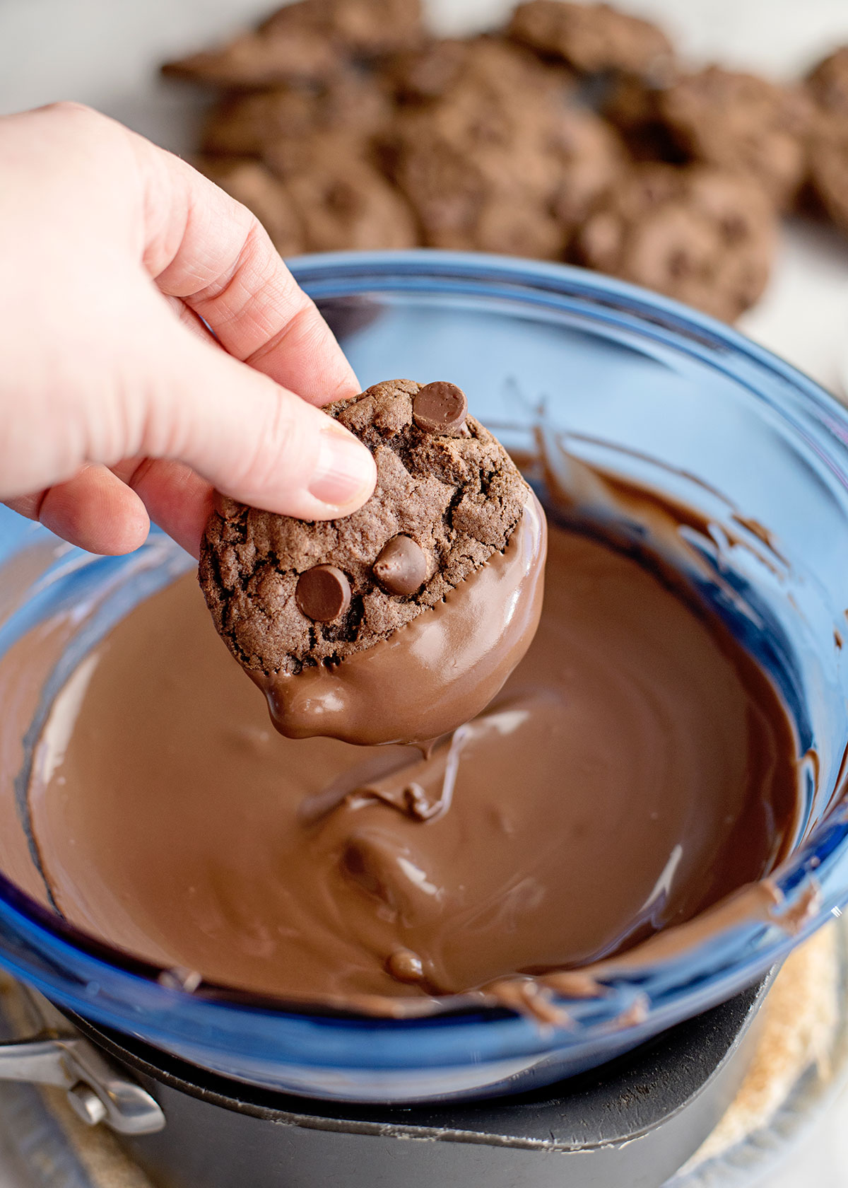 chocolate cookie dipped in a bowl of melted chocolate 