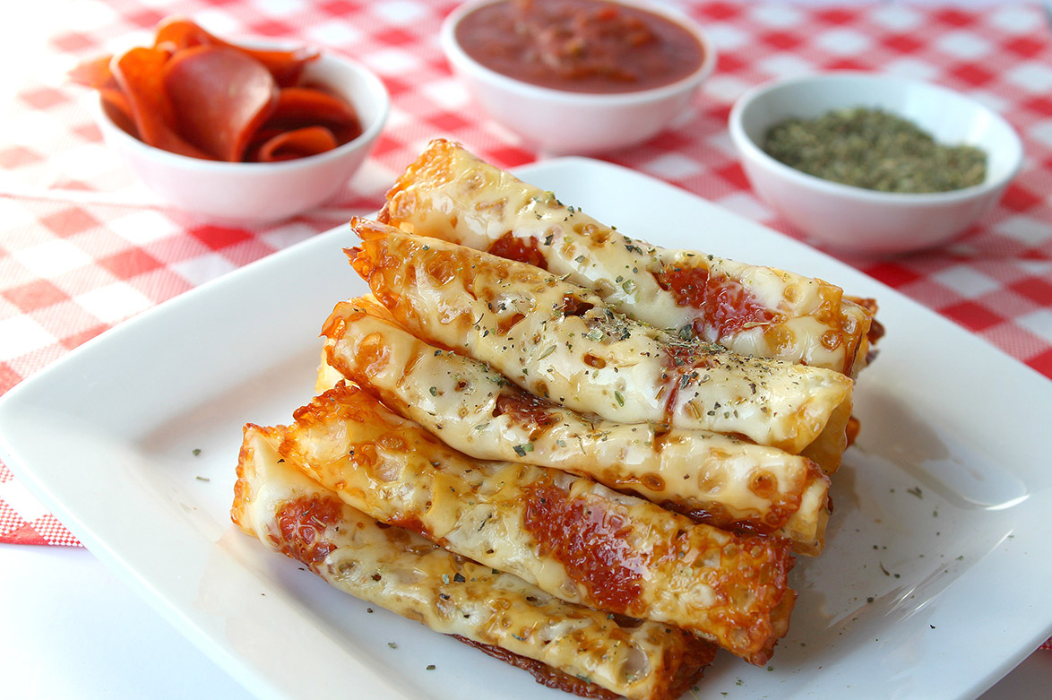 pizza rolls stacked on a white plate 