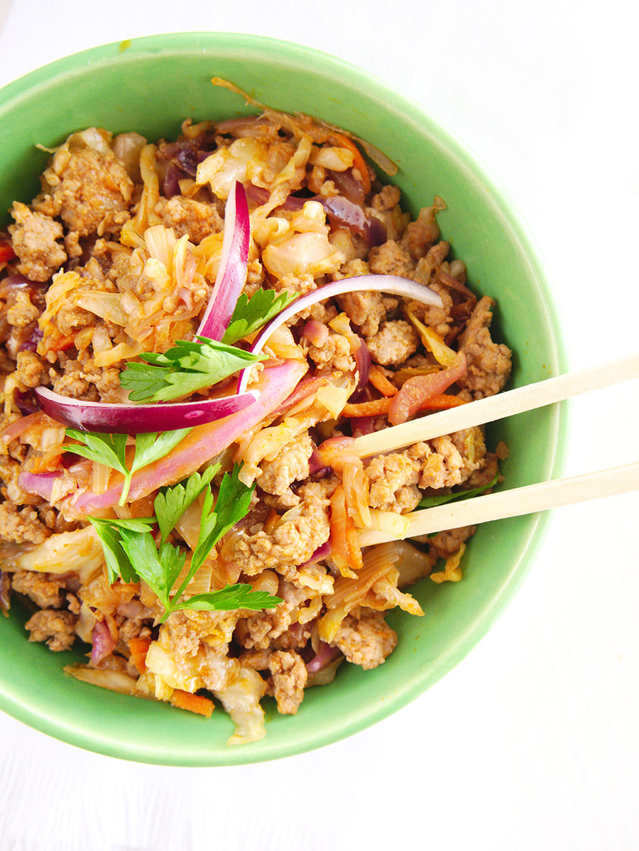 Pork eggroll in a green bowl with chop sticks.