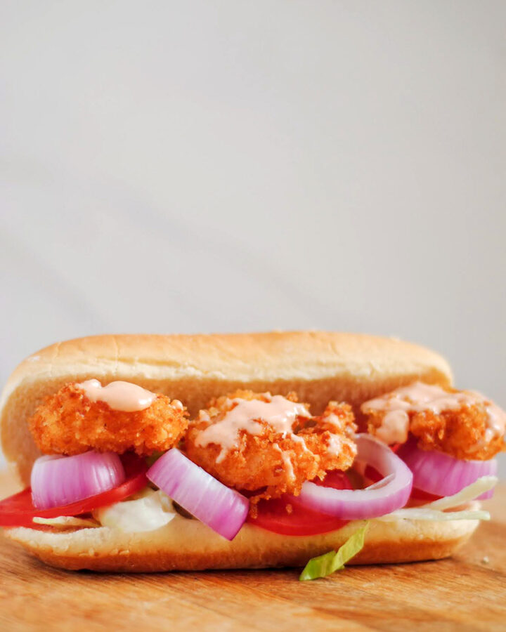 shrimp po'boy sandwich on a wooden board