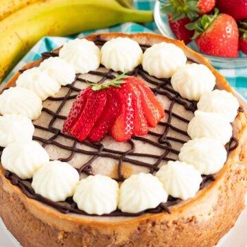 instant pot banana split cheesecake with strawberries and bananas in the background.