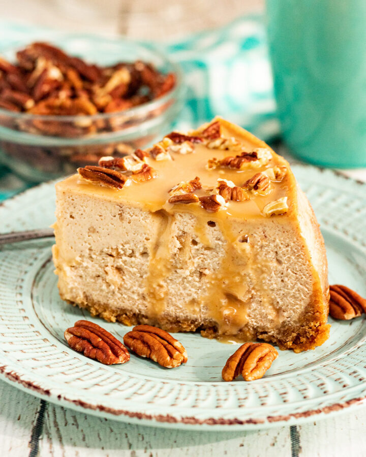 a slice of caramel apple cheesecake with pecans.