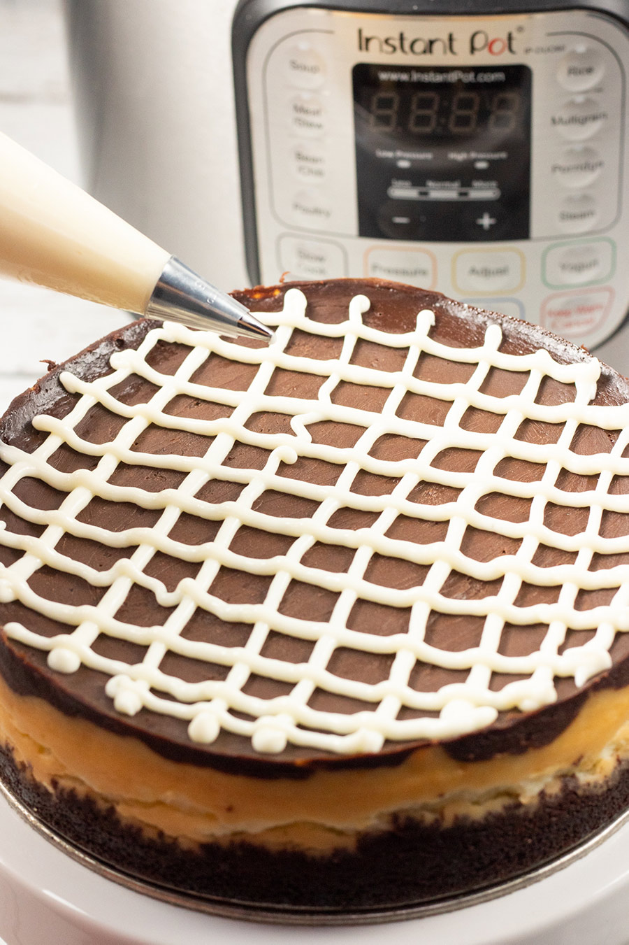 cheesecake being decorated with a piping bag. 