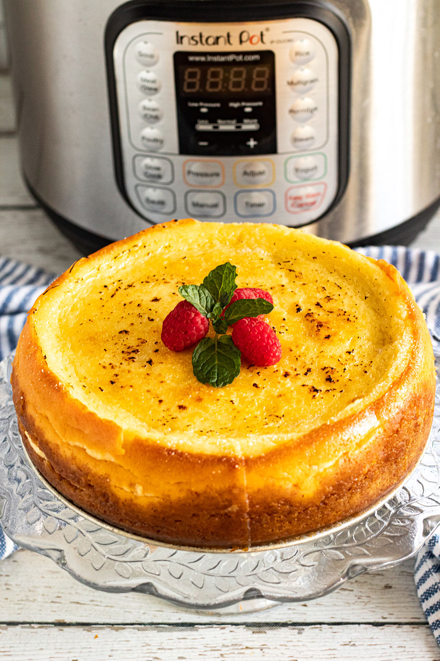 creme brulee cheesecake with raspberries and mint on top. 