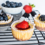 mini cheesecakes with strawberries, blueberries, and blackberries on top.