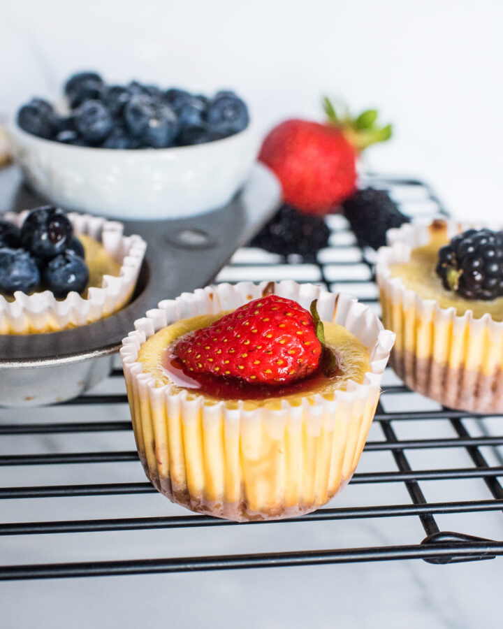 mini cheesecakes with strawberries, blueberries, and blackberries on top.