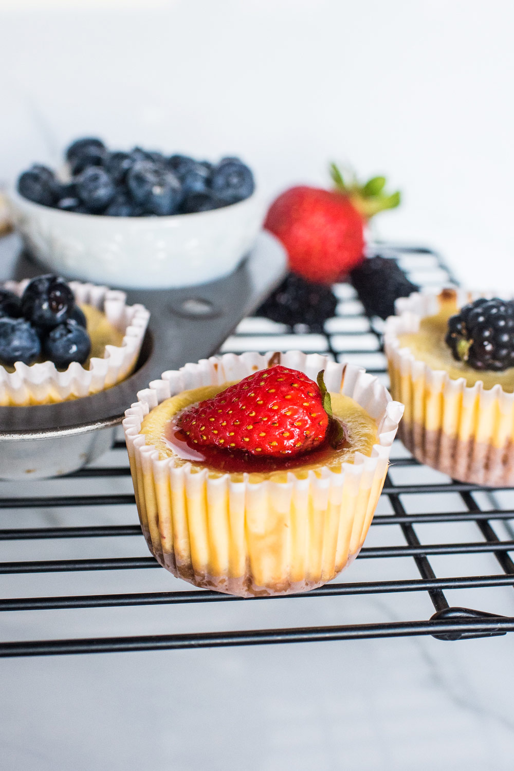 mini cheesecakes with strawberries, blueberries, and blackberries on top. 
