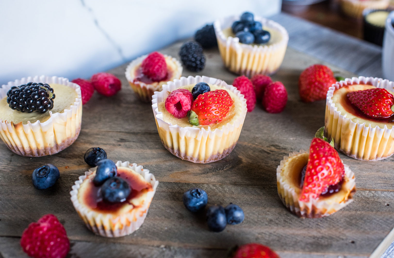 mini cheesecakes with mixed fruits on a platter. 