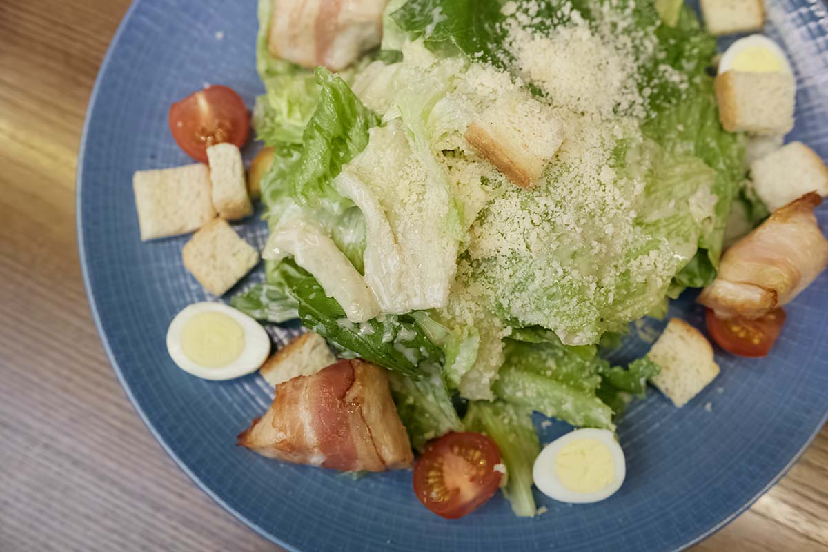Caesar salad on a blue plate.
