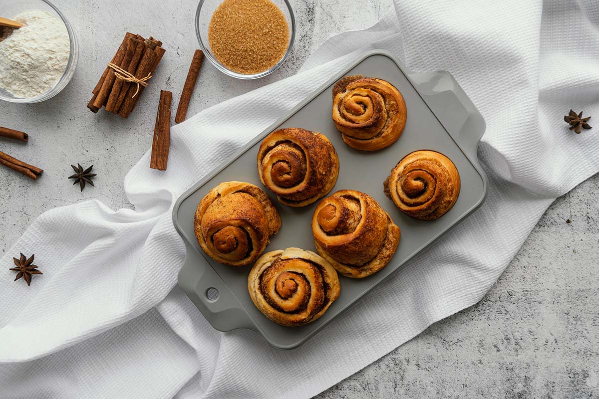 six cinnamon rolls in a baking pan.