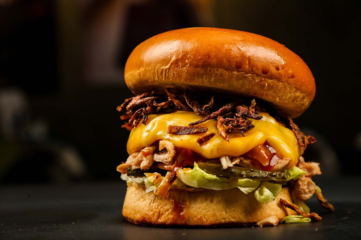 grilled onion cheddar burger up close.