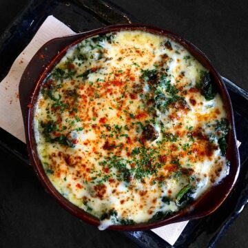 keto spinach dip with melted cheese and parsley on top.