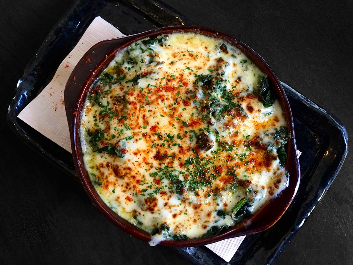 keto spinach dip with melted cheese and parsley on top. 