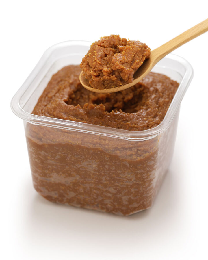 miso paste in a container with a spoon.