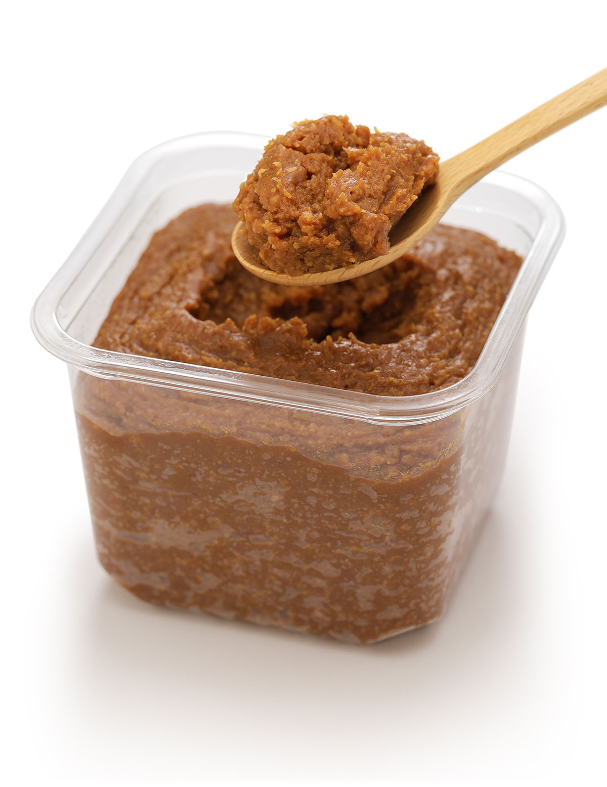 miso paste in a container with a spoon. 
