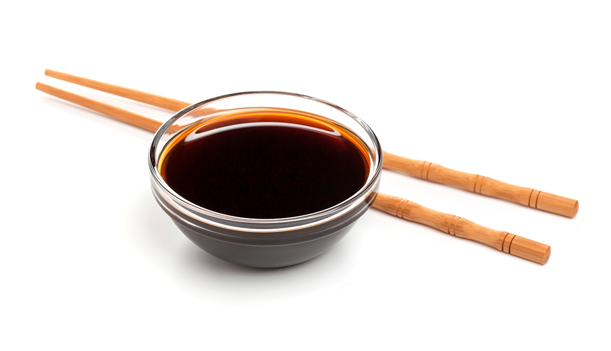 soy sauce in a small bowl with chopsticks on the side.