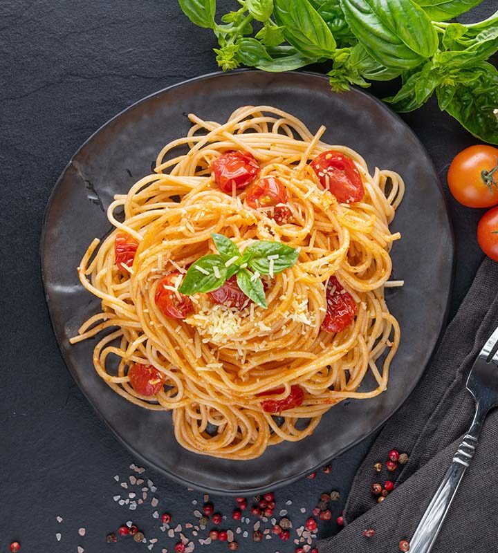 vegetarian spaghetti with tomatoes, basil, and oil on the side.
