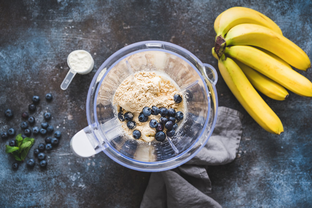 blueberries, bananas, and protein powder in a blender.