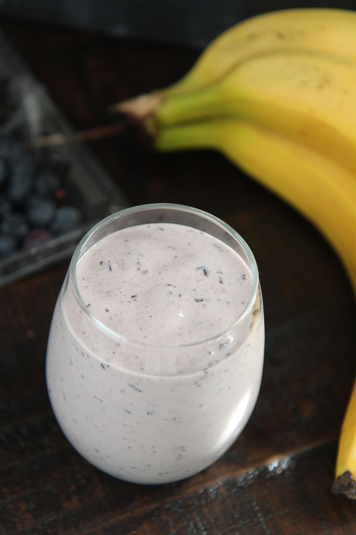 blueberry banana smoothie with bananas and blueberries on the side.