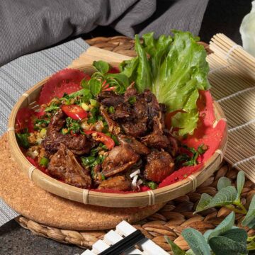 grilled dove in a bowl with lettuce on the side.