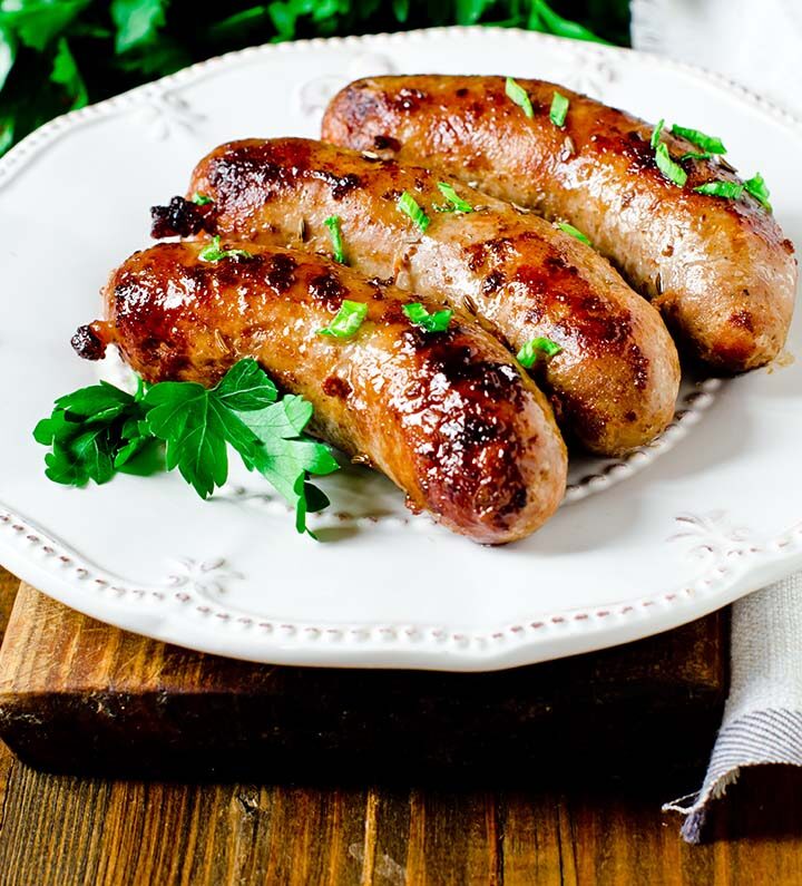 Three Italian sausages on a white plate.