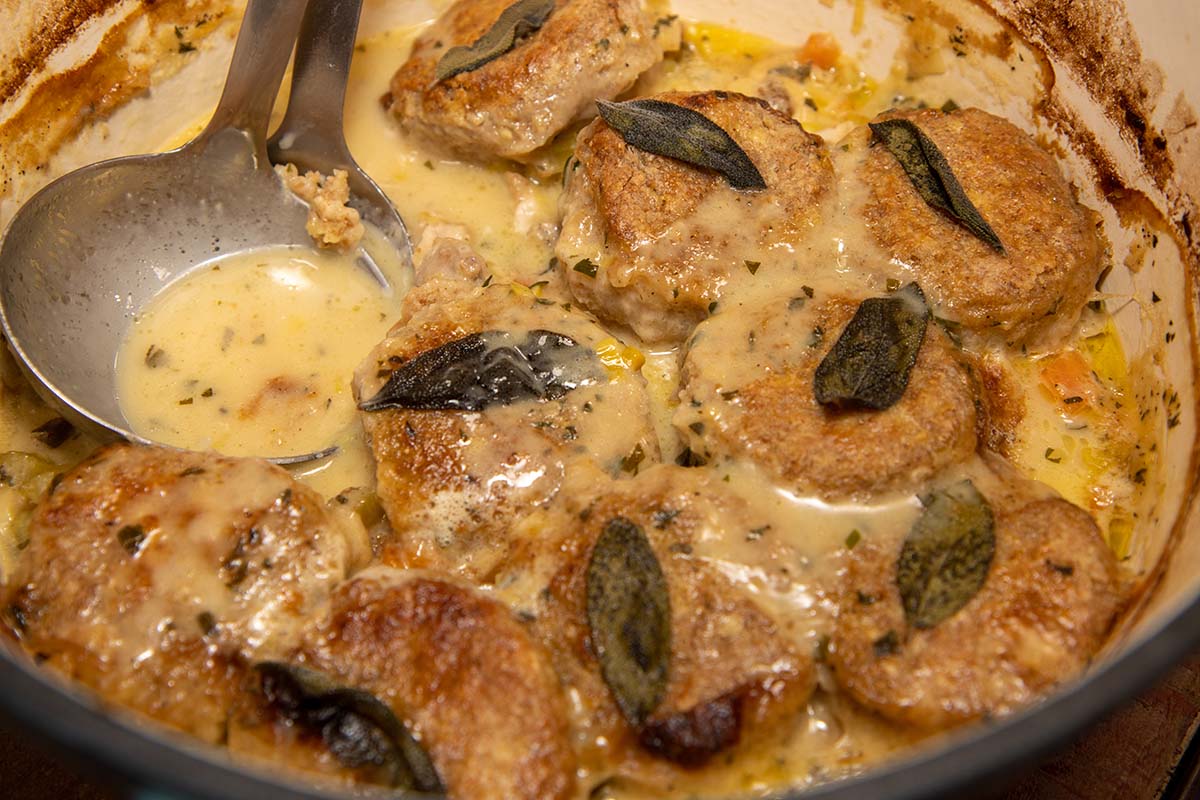 chicken cobbler in a dutch oven with a ladle.