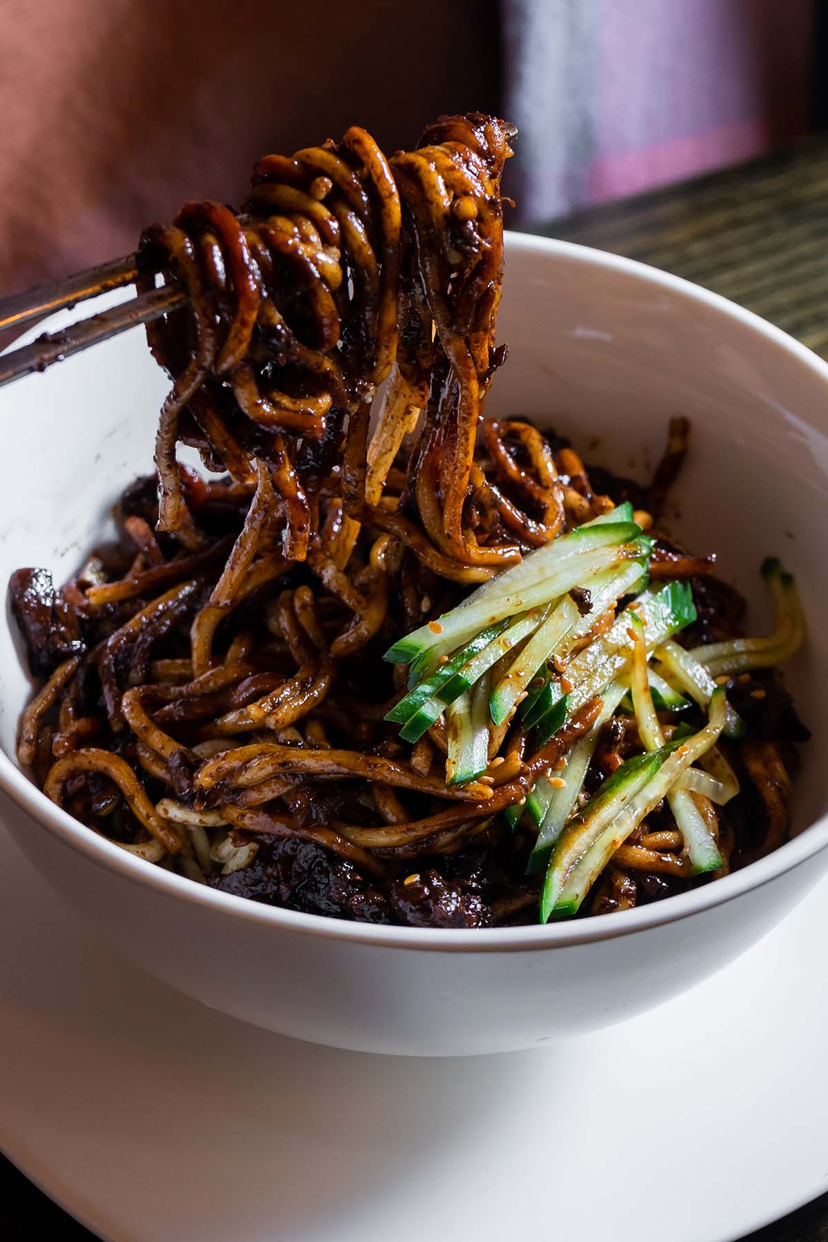 vegan korean noodles in a white bowl with chopsticks.