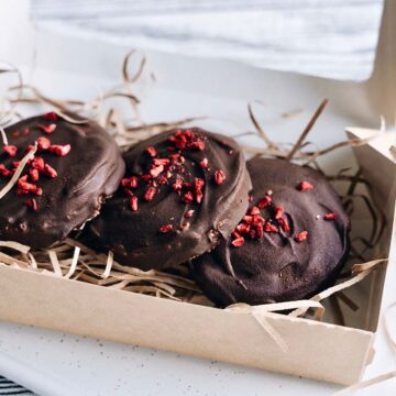 Three chocolate dried cherry cookies in a box.
