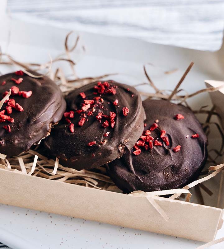 Three chocolate dried cherry cookies in a box.