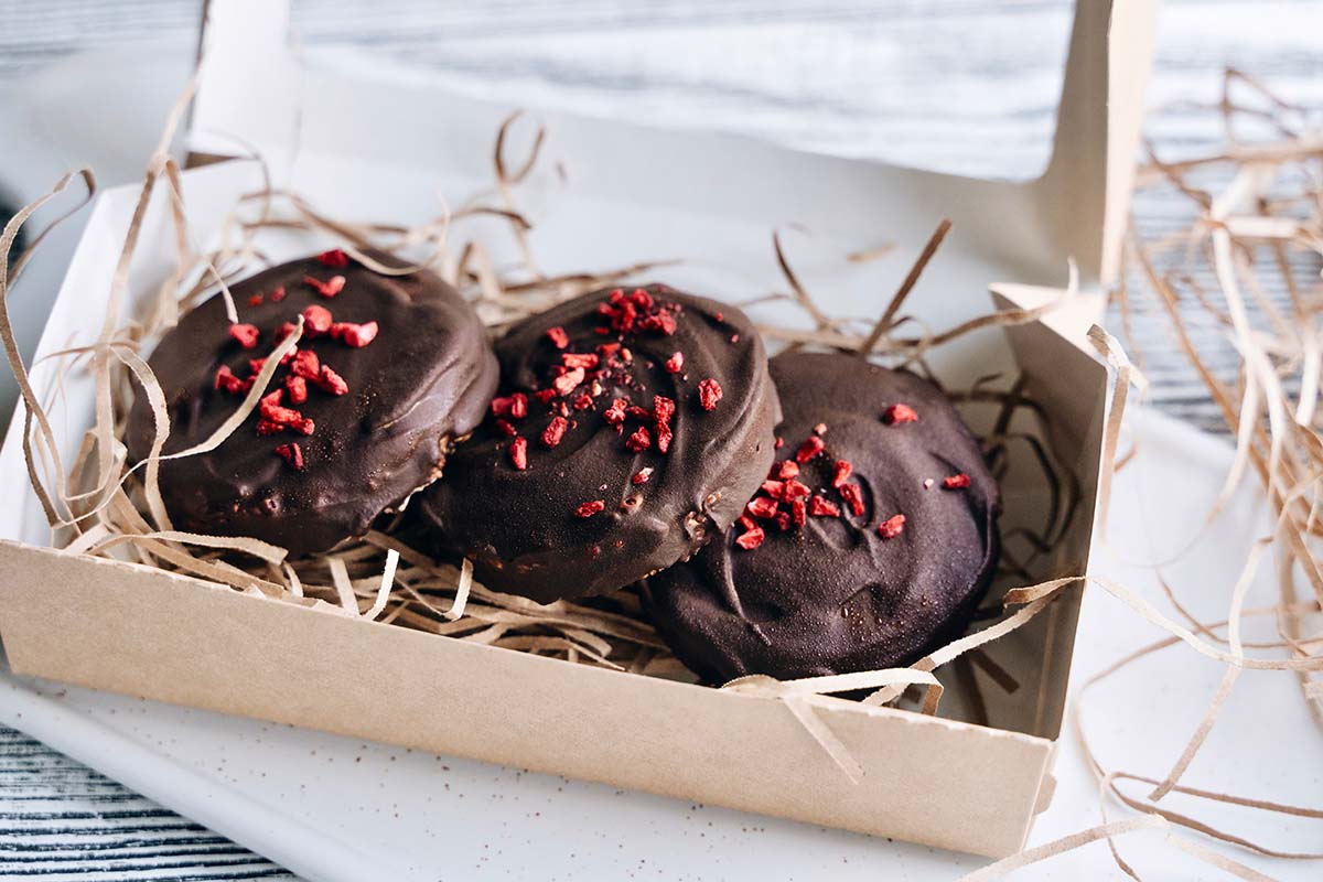 Three chocolate dried cherry cookies in a box. 
