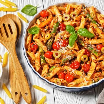 ground turkey pasta in a white bowl with wooden spoons on the side.