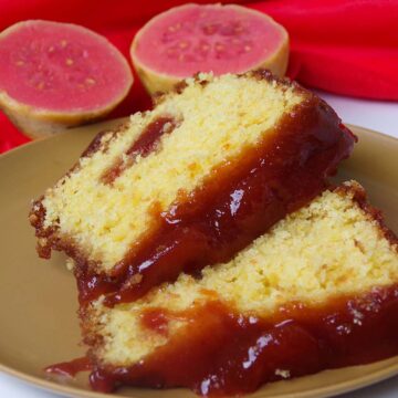 two slices of guava cake with a guava fruit in the background.