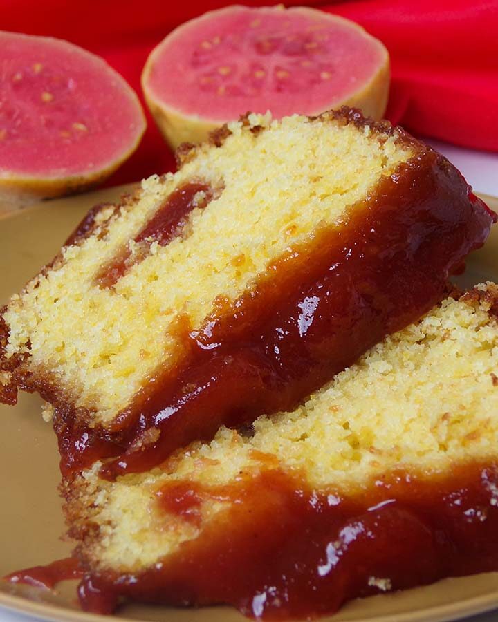 two slices of guava cake with a guava fruit in the background.