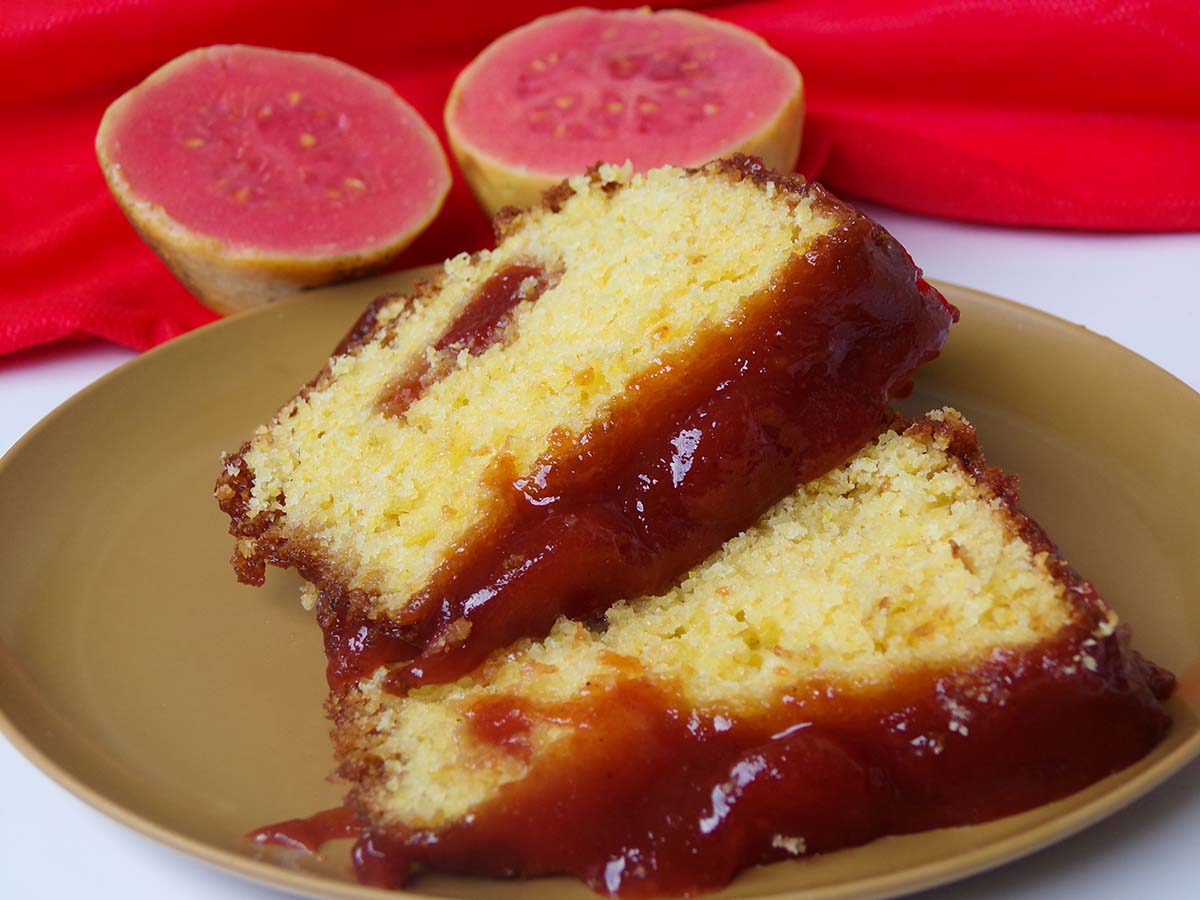 two slices of guava cake with a guava fruit in the background.