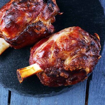 two cooked ham hocks on a plate.