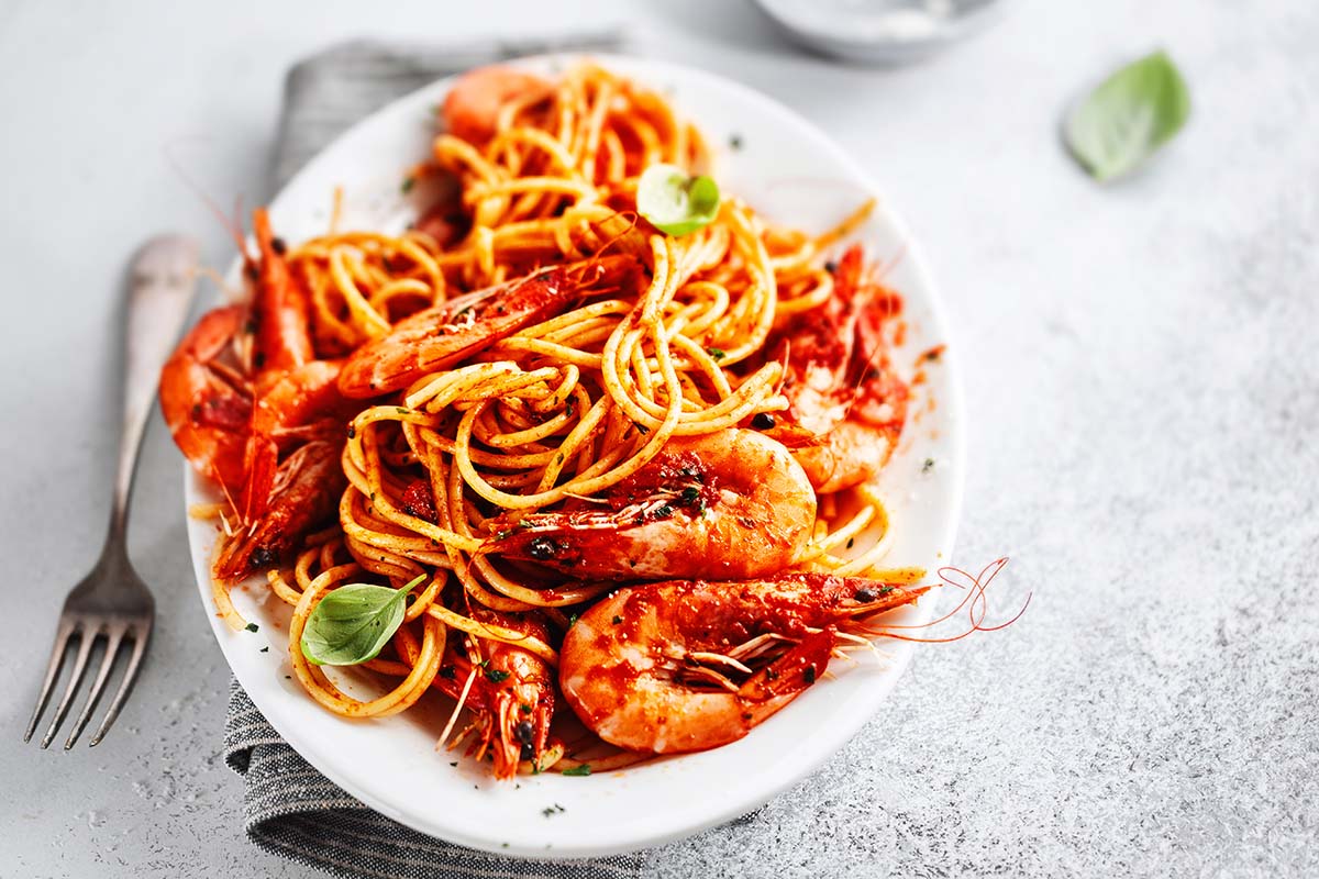 langostino pasta with red sauce in a white bowl. 