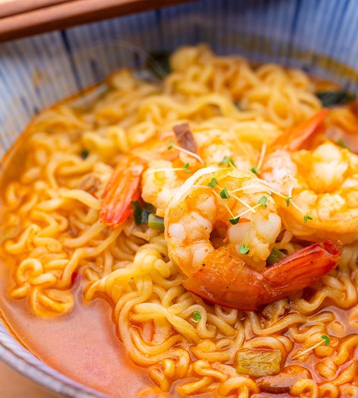 shrimp ramen in a bowl with chopsticks on the side.