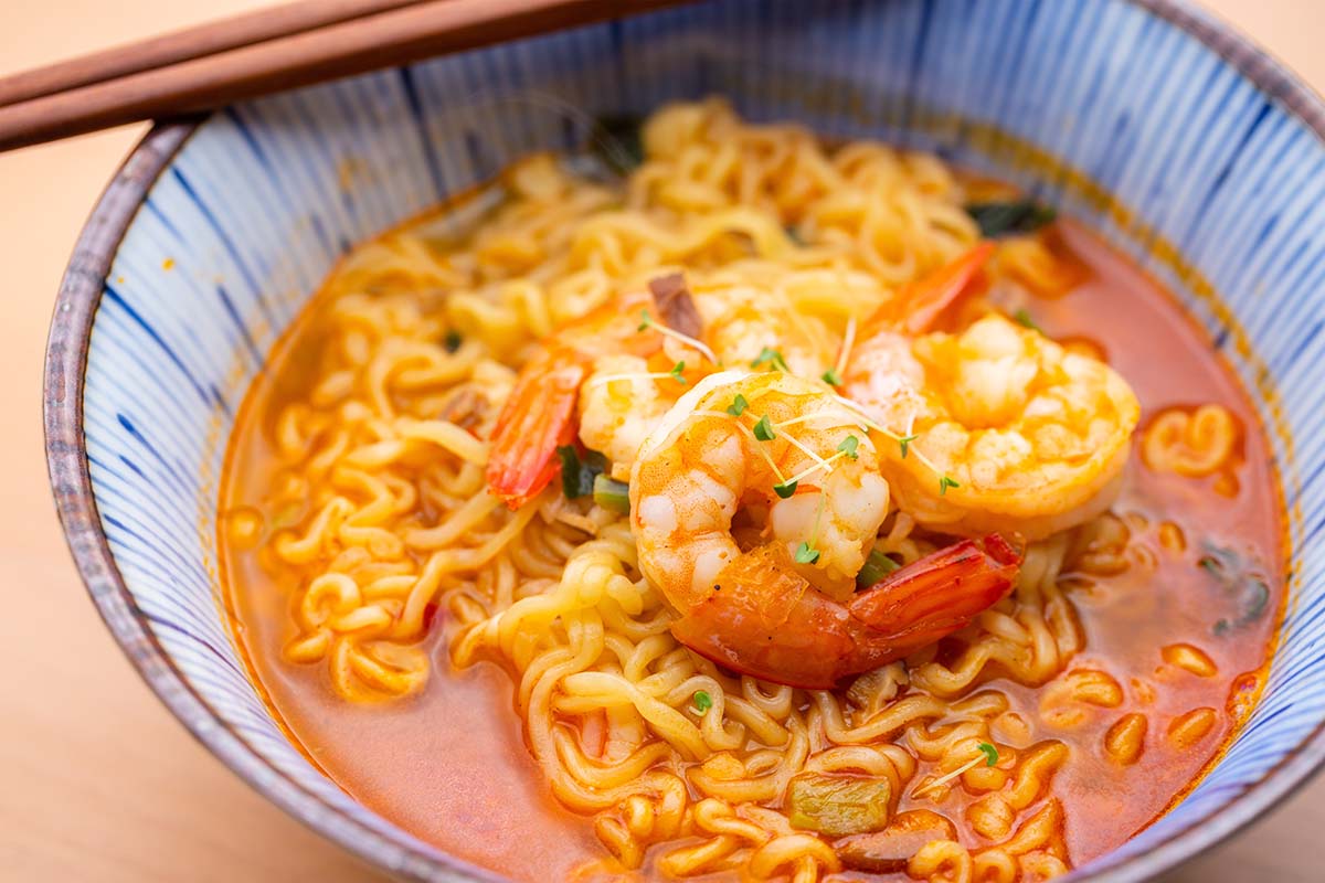 shrimp ramen in a bowl with chopsticks on the side. 