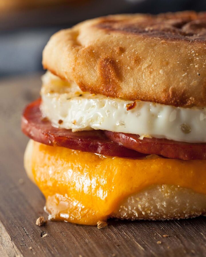 taylor ham, egg, and cheese breakfast sandwich on a wooden board.