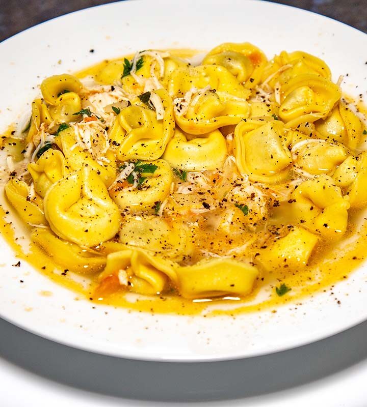 chicken tortellini in a white bowl.