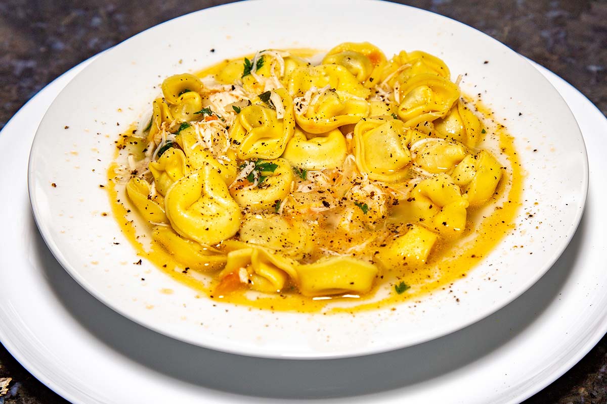 chicken tortellini in a white bowl.
