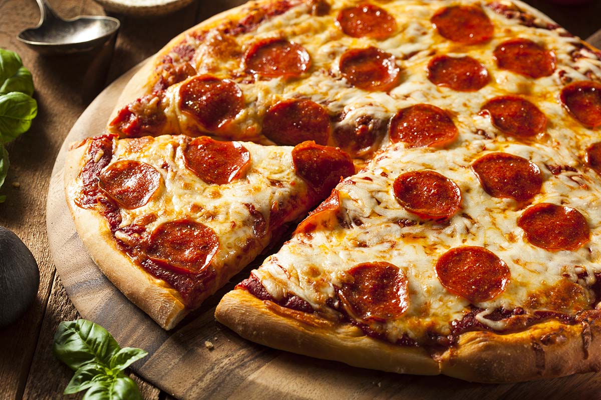 pepperoni pizza on a wooden board.