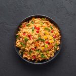 yellow rice with vegetables in a bowl.