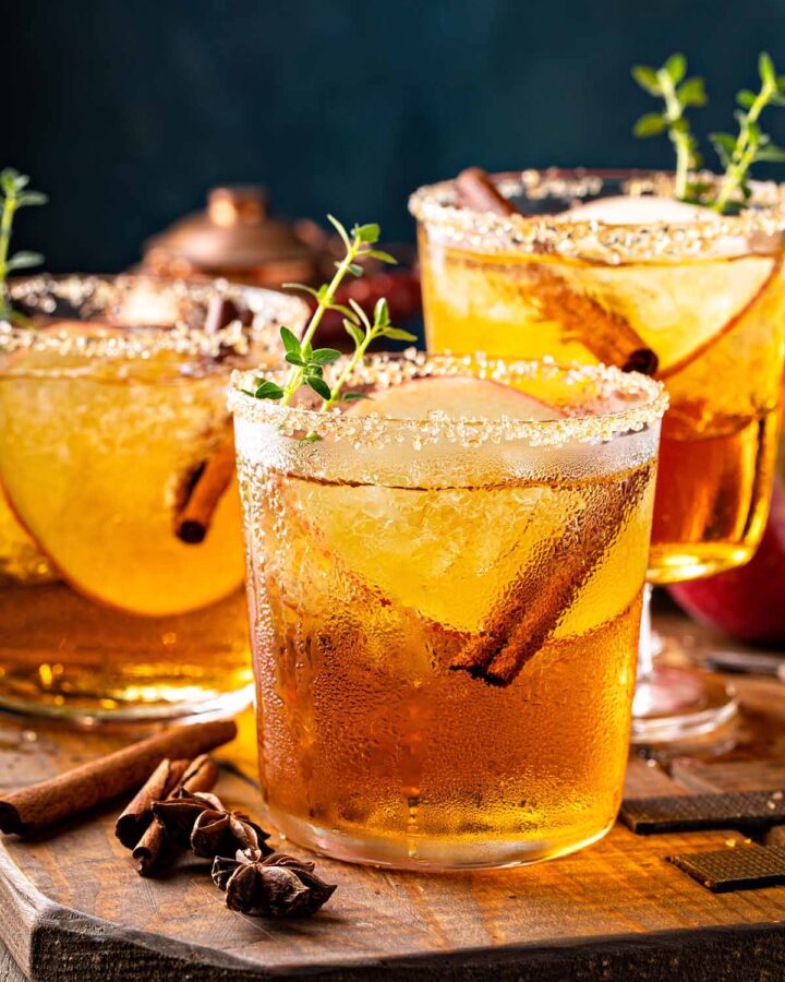 Three crown apple cocktails on a wooden board.