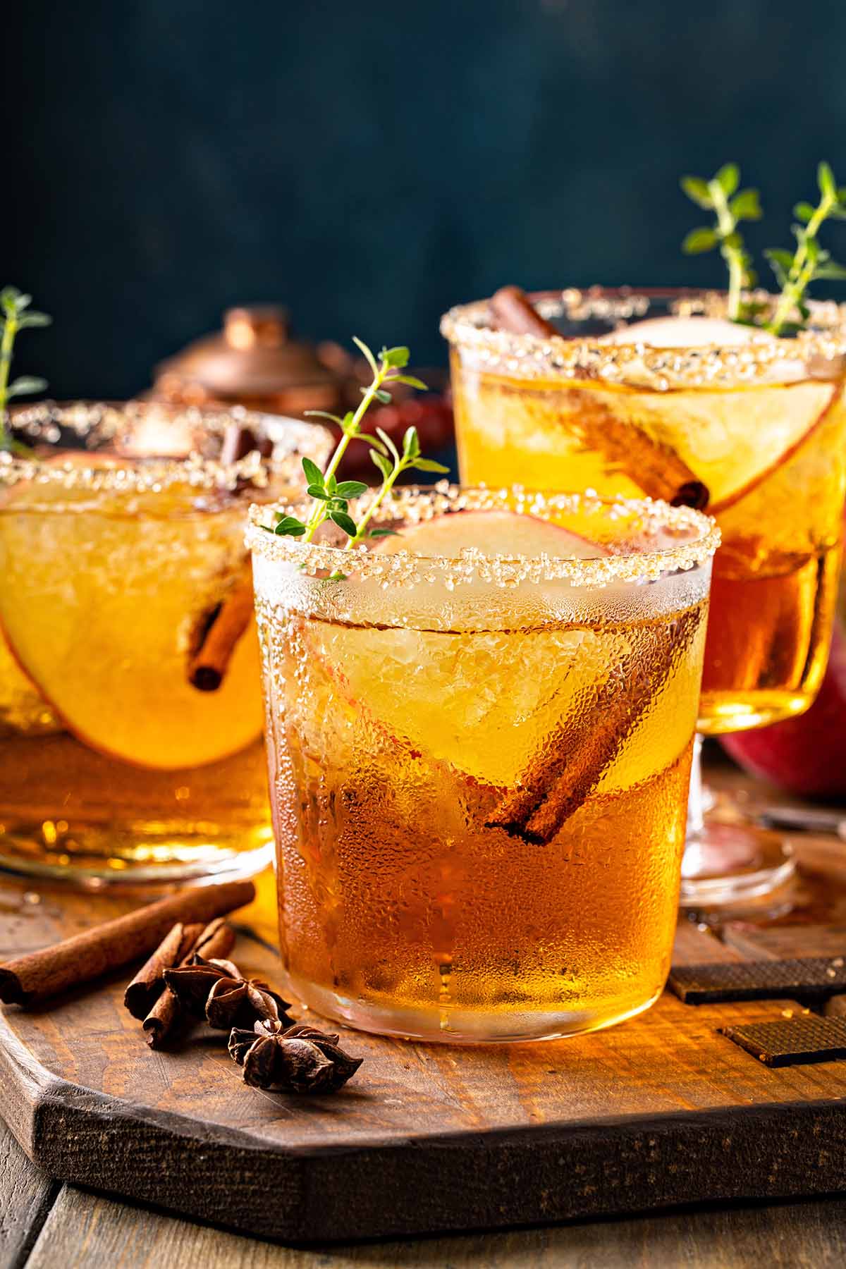 Three crown apple cocktails on a wooden board.