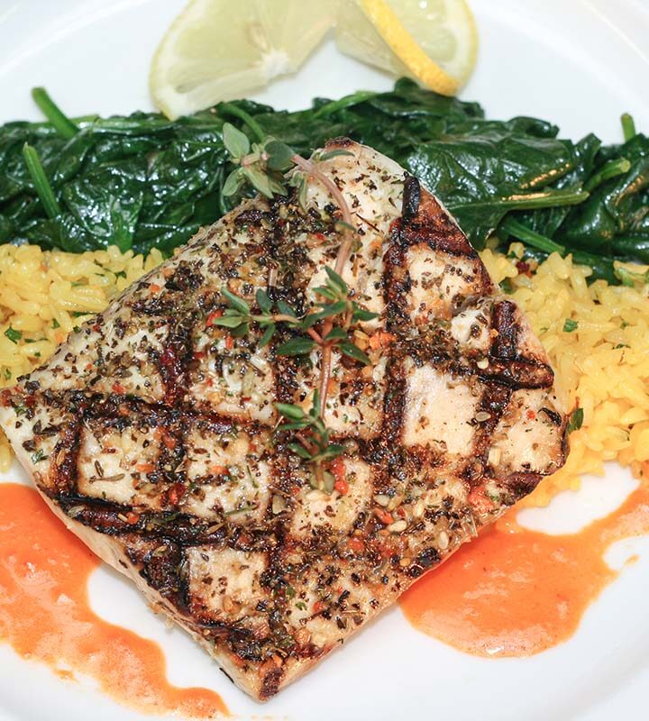 grilled wahoo with yellow rice, sauteed spinach, and lemon.